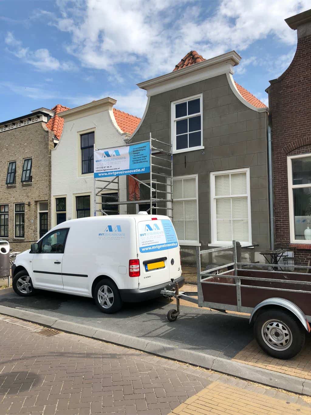 De werk bus van MVT Gevelrenovatie die voor een steiger staat