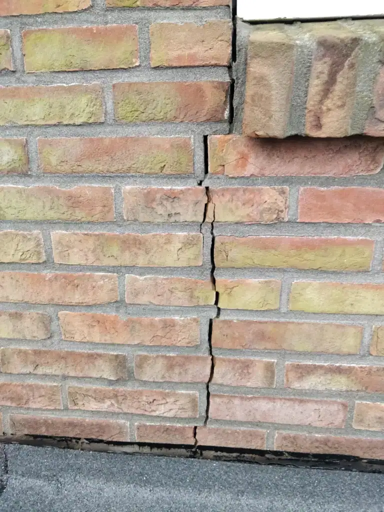 Gevel met haarscheurtjes die wijzen op mogelijke schade en onderhoudsbehoefte